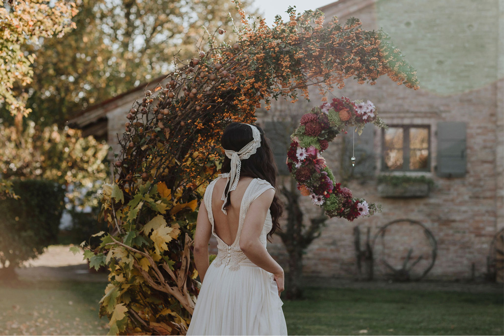 Un arco floreale a forma di mezzaluna per un matrimonio autunnale e bohémien