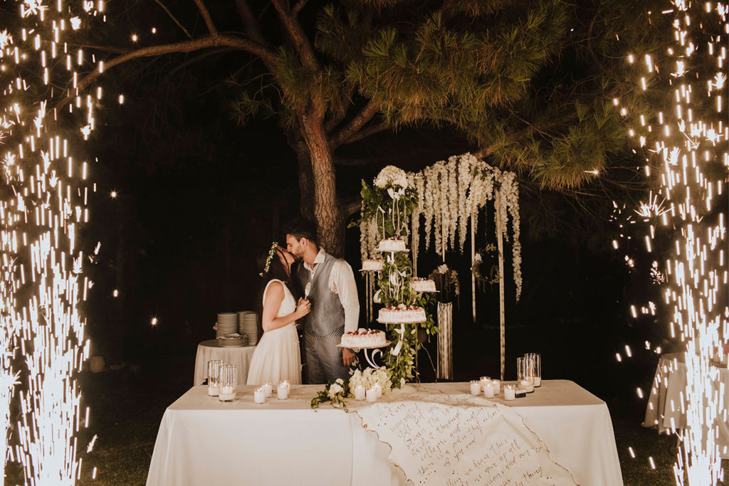 Il momento del taglio torta durante un matrimonio in un giardino di Venezia