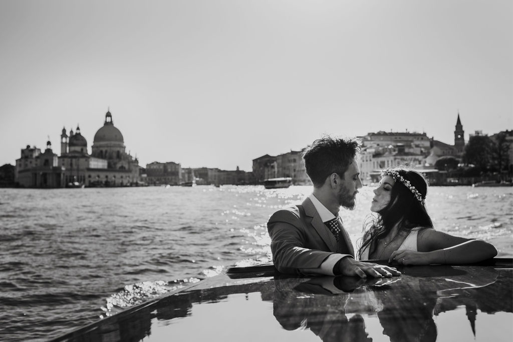 Il bacio di una coppia di sposi su un taxi acqueo a Venezia in bianco e nero