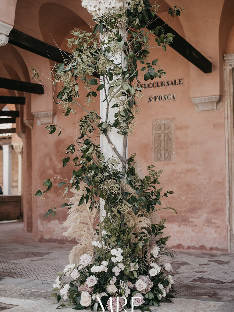 Un dettaglio di un allestimento floreale in chiesa durante un matrimonio alla Locanda Cipriani